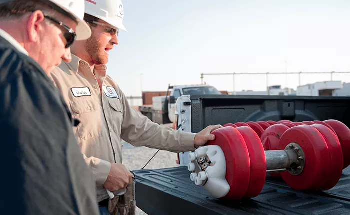 Pigging technicians examining pipeline pigs in a truck bed before the are launched into the line