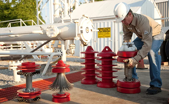 Technician preparing to load several pigs into a launcher for a progressive pigging job