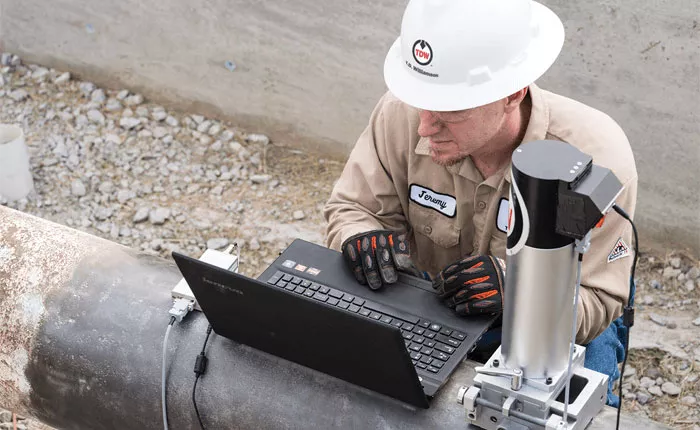 ASNT Certified TDW technician inspecting a pipeline using NDE tools