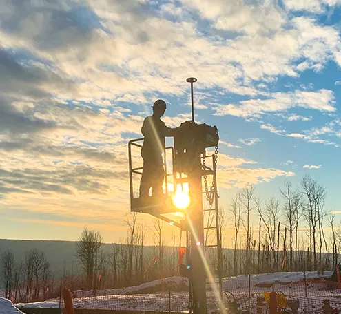 Pipeline technician on a job site at sunset