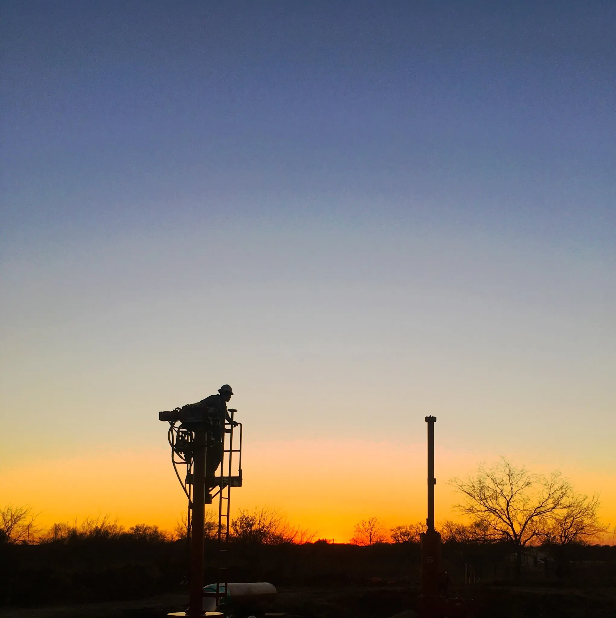 Pipeline hot tapping jobsite photo showing a tapping machine set on a line at sunset